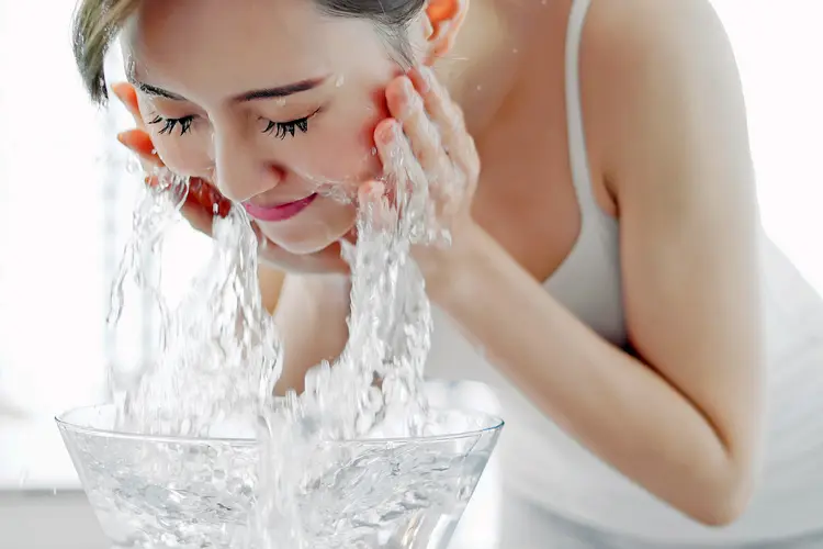photo of woman washing her face
