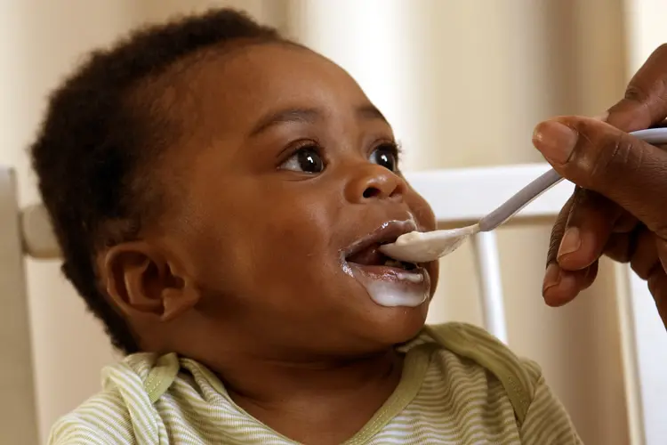 Baby being fed yoghurt