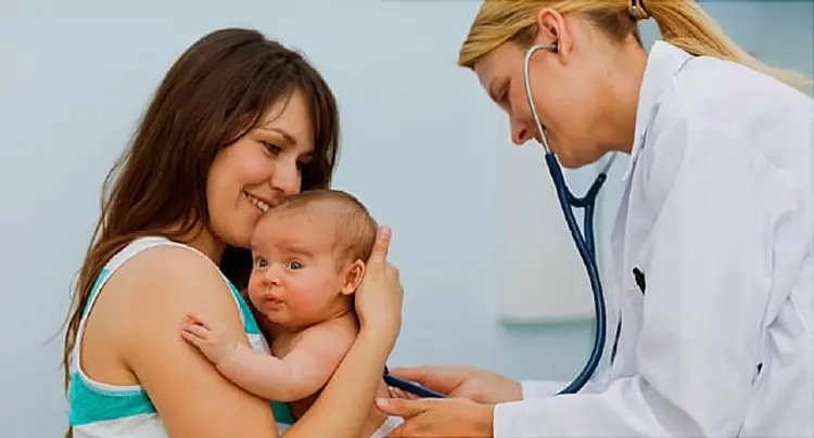 Mother holding a baby in an examination room with