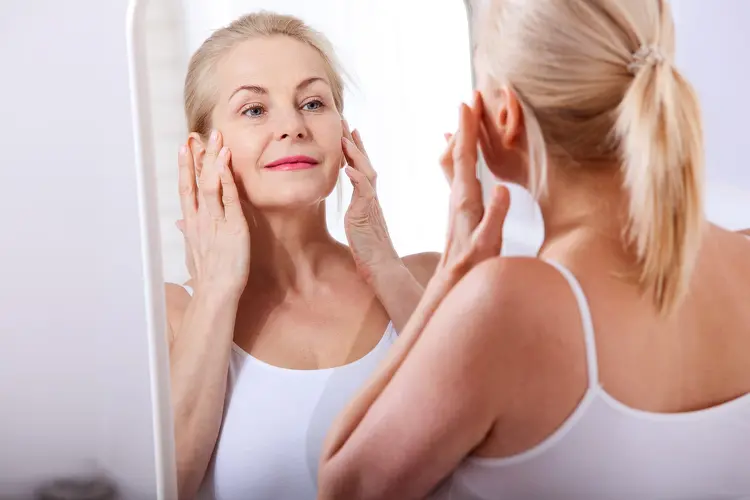photo of mature woman looking in mirror