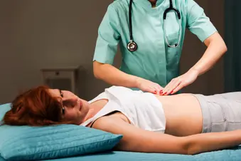 nurse pushing on womans stomach