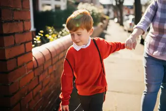 photo of boy holding parents hand
