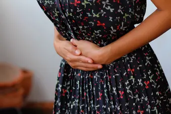 photo of woman holding stomach