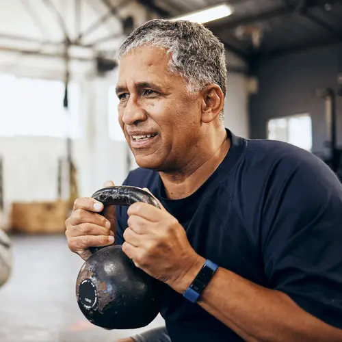 photo of mature man working out with kettlebell