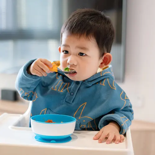 photo of toddler eating with spoon