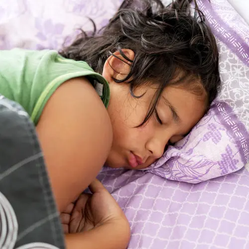 photo of young girl sleeping in bed