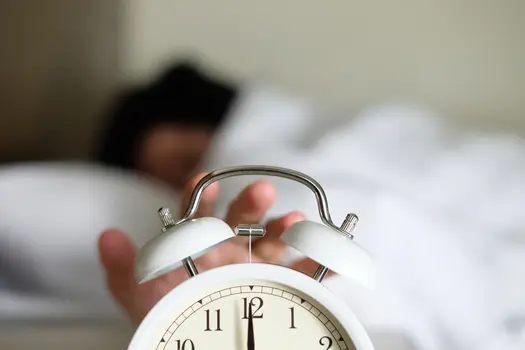 photo of hand turning off alarm clock