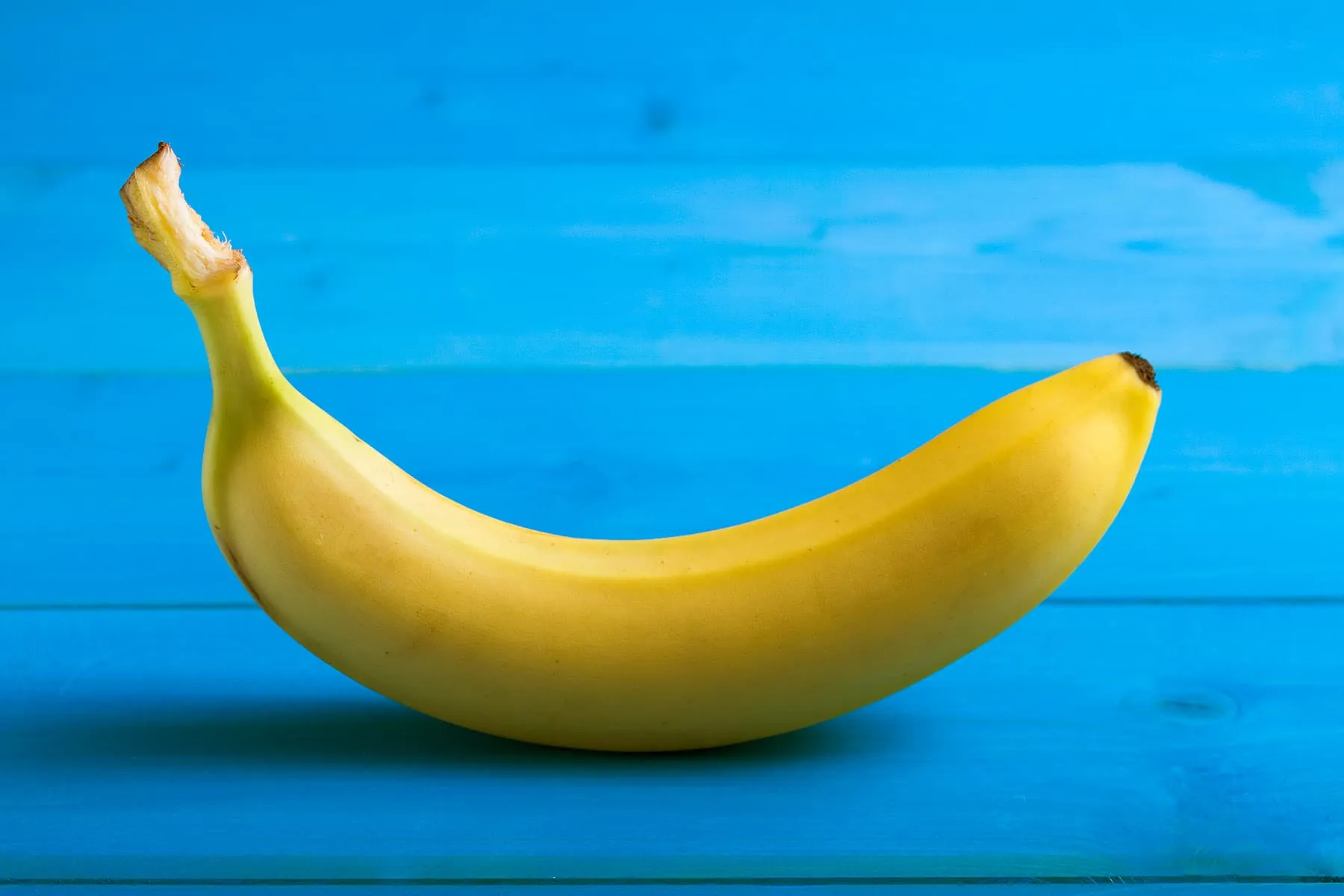Картинка банан. Банан. Бананы на голубом фоне. Натуральный банан. Желтый банан.