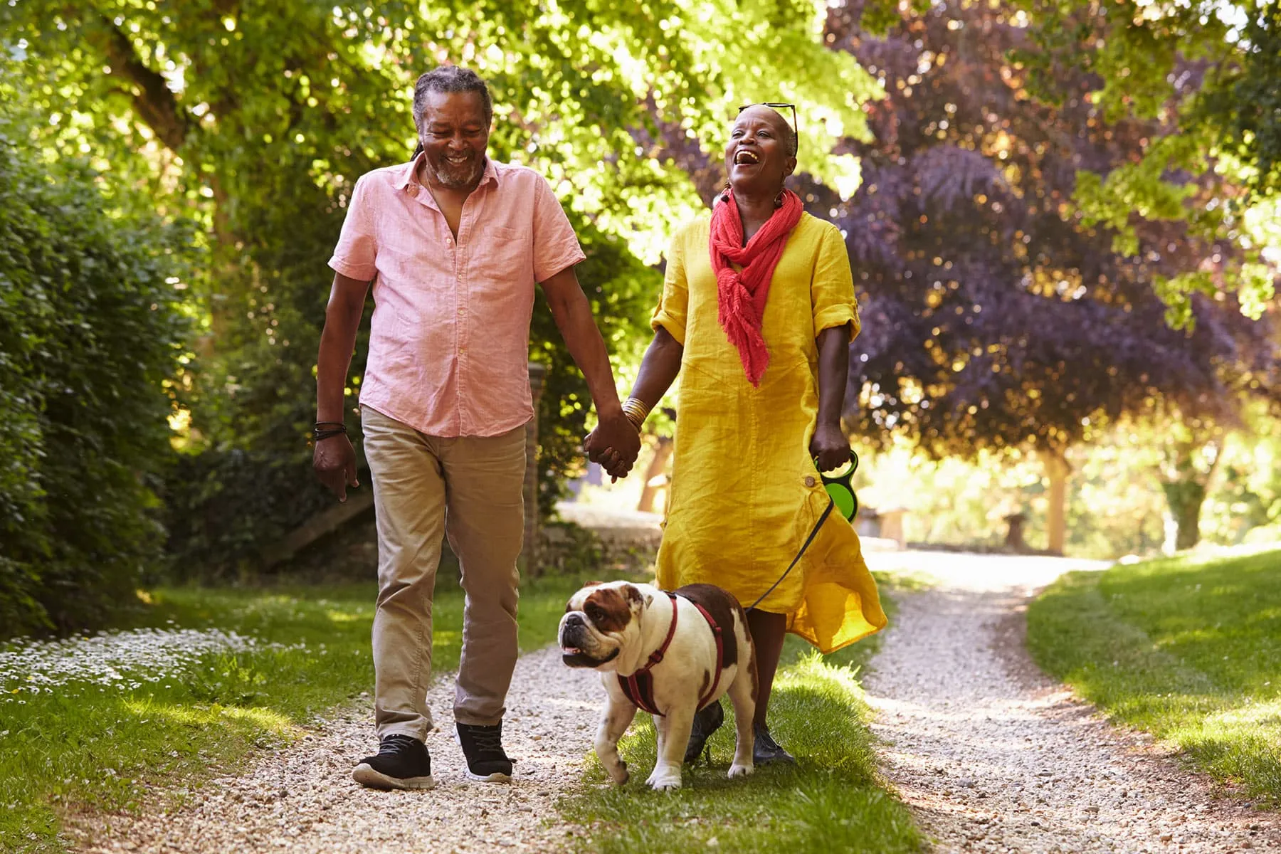 photo of couple walking dog outside