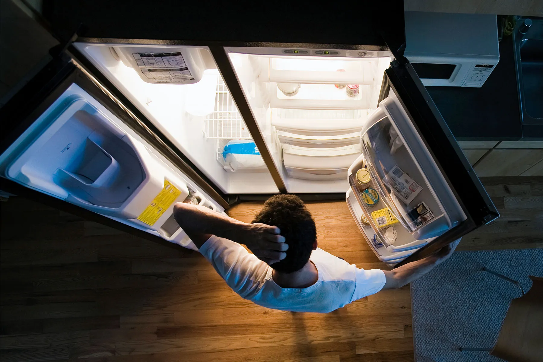 photo of looking in fridge at night