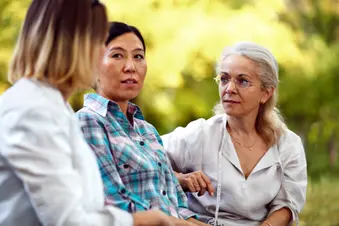 photo of three mature women talking in park
