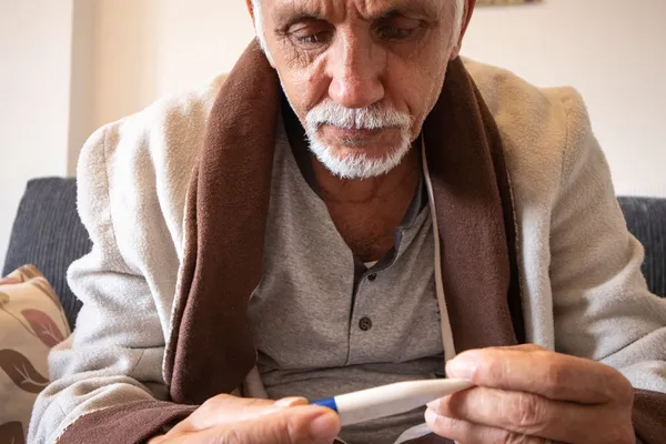 man looking at thermometer