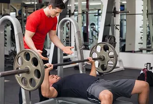 Make sure you have a spotter, someone watching and helping for safety, when you bench press. Photo credit: Getty Images.