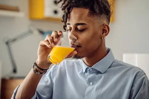 photo of man drinking orange juice