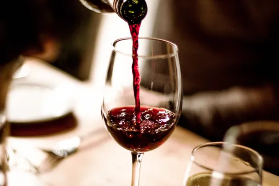 photo of pouring glass red wine