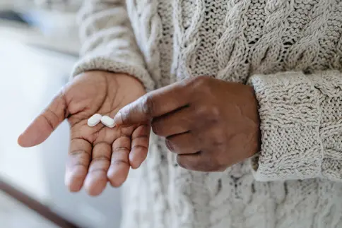 photo of person with pills in hand