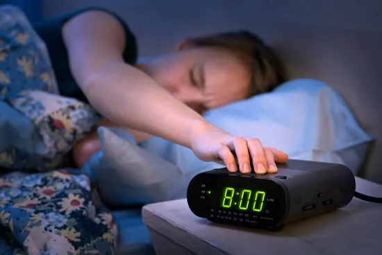 teenager hitting snooze button