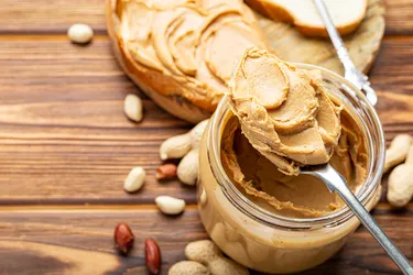 Peanut butter is a thick paste made of ground peanuts that is an excellent source of protein. Photo Credit: Beton studio / Getty Images