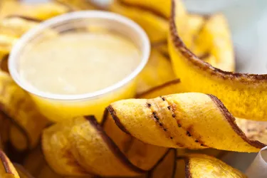 Plantains are starchier and less sweet than bananas. They are usually cooked before serving. (E+ / Getty Images)