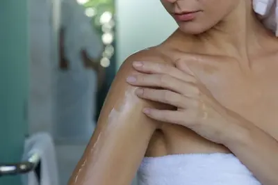 photo of woman applying cream to arm