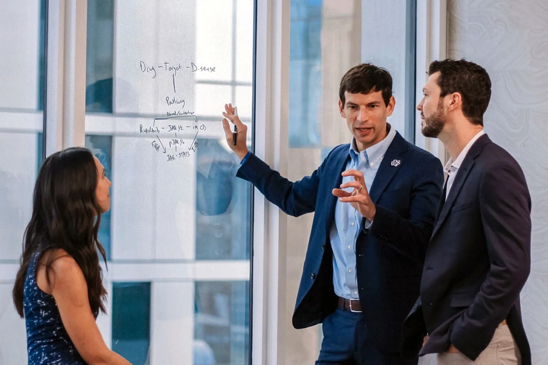 David Fajgenbaum, center, confers with colleagues at Every Cure.